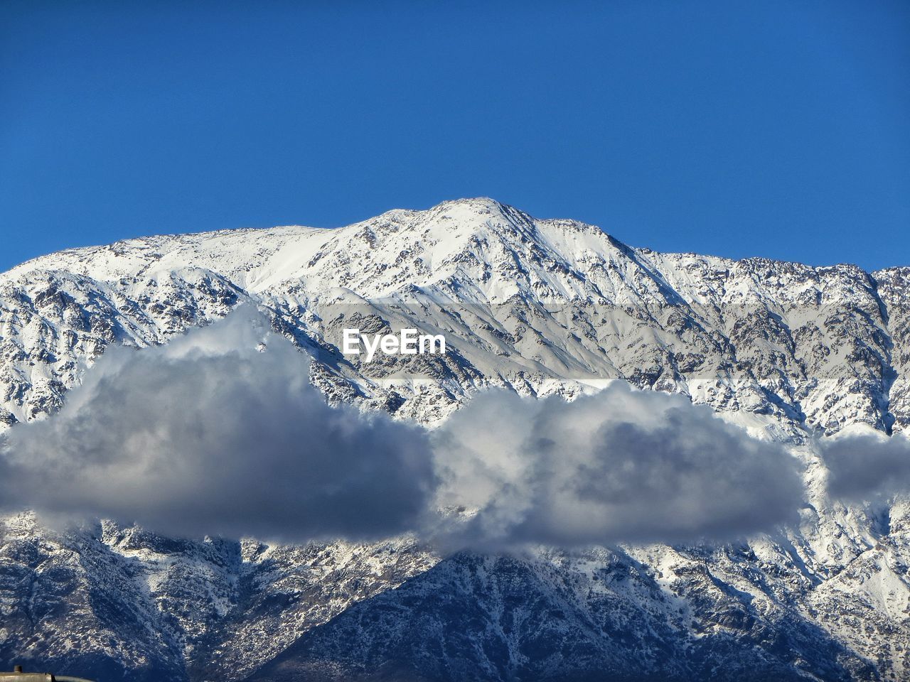 Scenic view of snowcapped mountains against clear blue sky