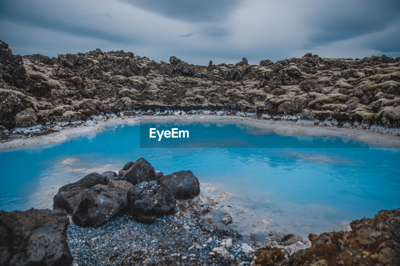 ROCKS ON SHORE AGAINST SKY