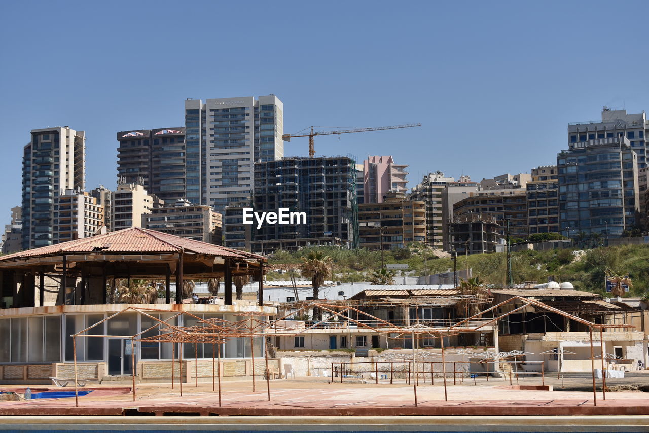 Buildings in city against clear blue sky