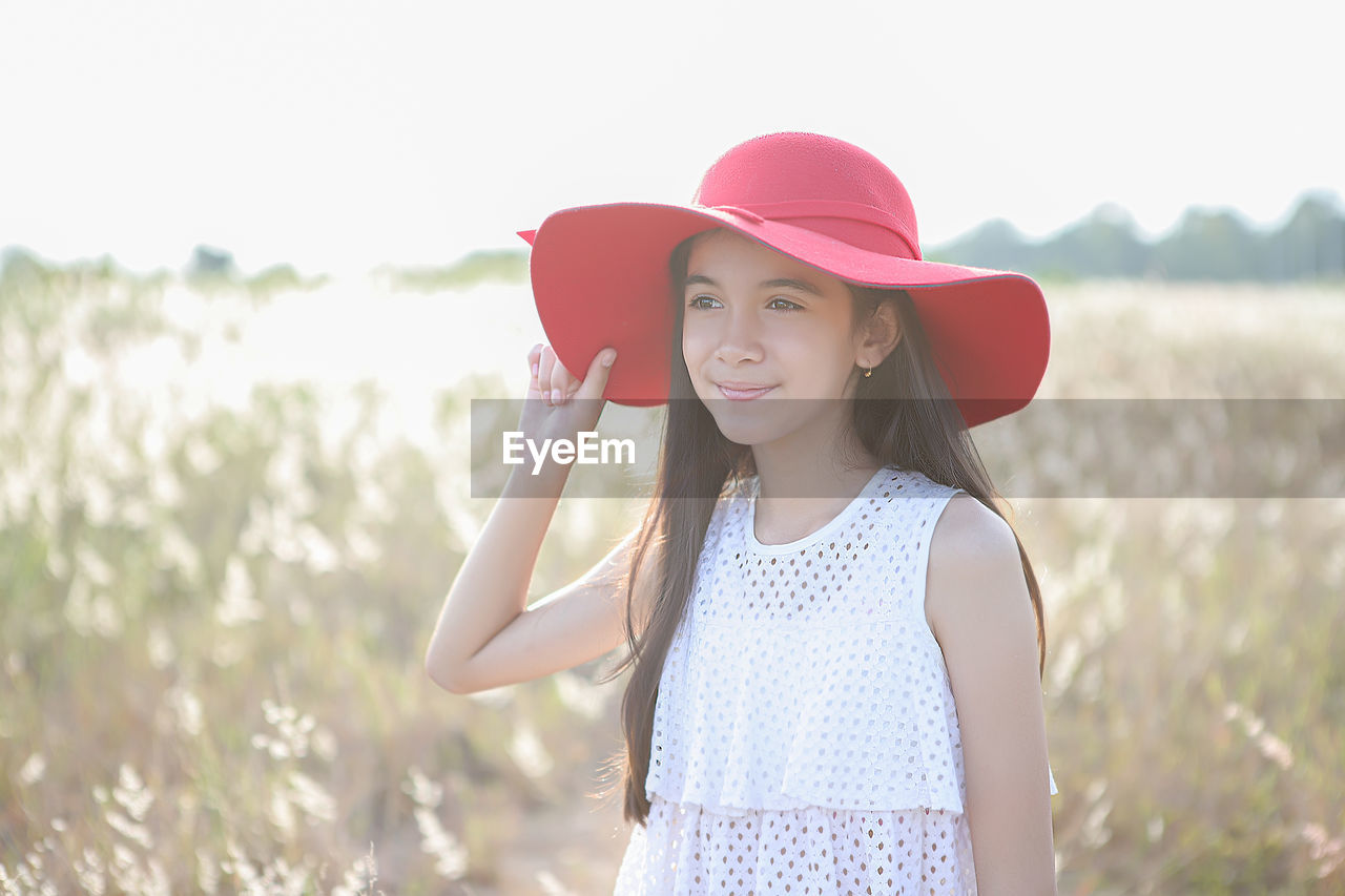 Girl looking away while standing on land