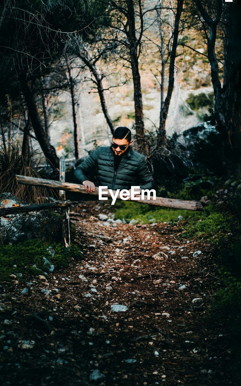 Man standing by trees in forest