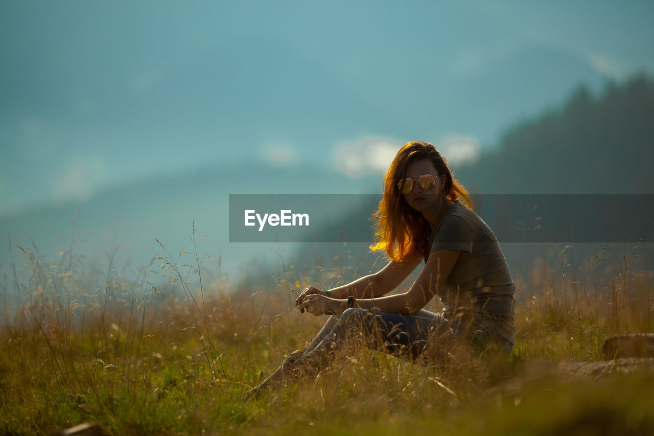 Girl sitting on the grass in the carpathian mountains