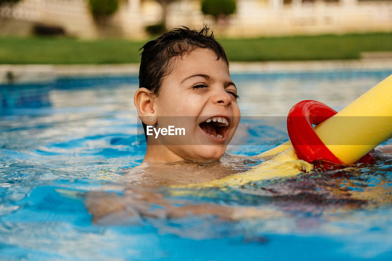 Smiling boy swimming in pool