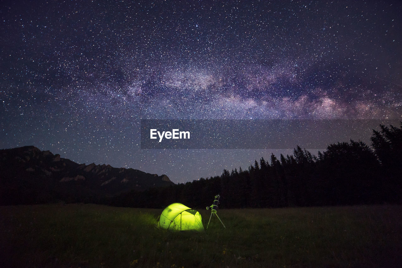 Camping tent at night against amazing sky full of stars and milky-way