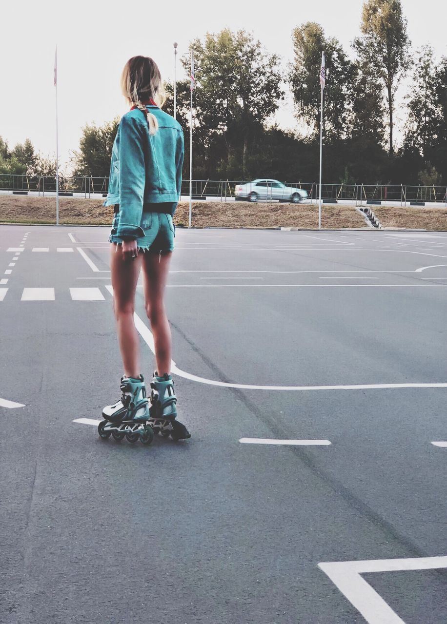 Rear view of woman inline skating on road