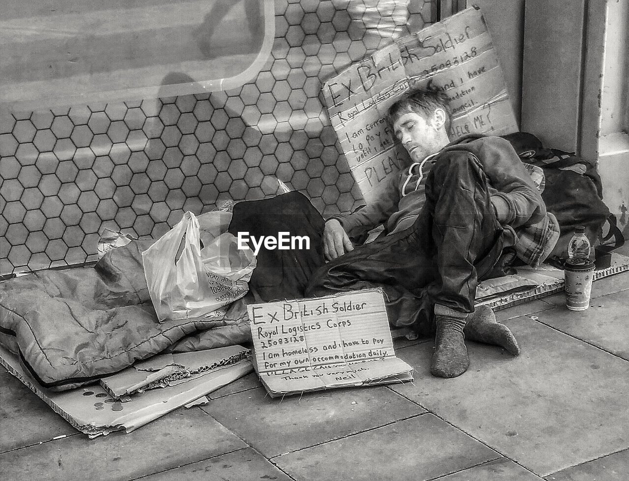 FULL LENGTH OF A MAN SITTING ON FLOOR IN CITY