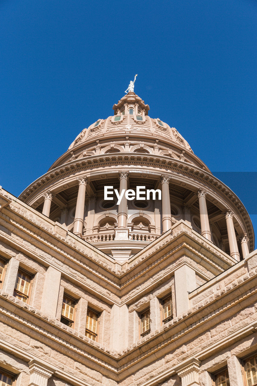 LOW ANGLE VIEW OF HISTORIC BUILDING AGAINST CLEAR BLUE SKY