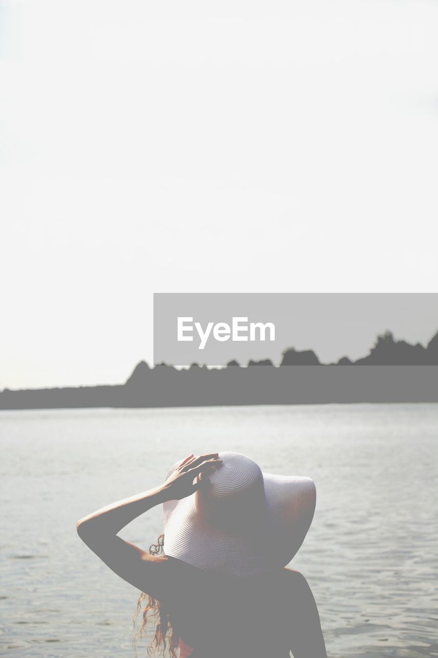 Woman wearing sun hat looking at lake