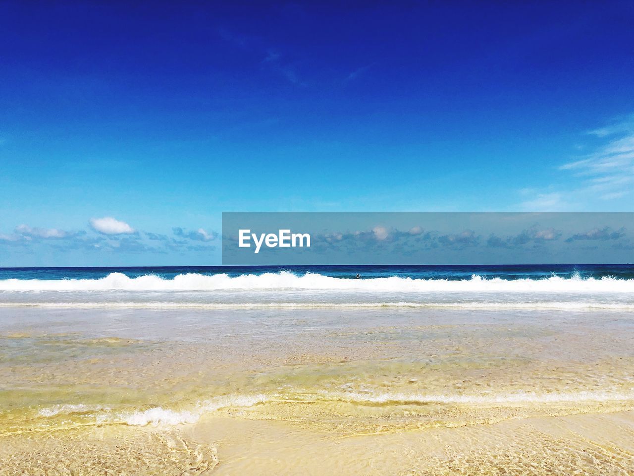 Scenic view of beach against blue sky