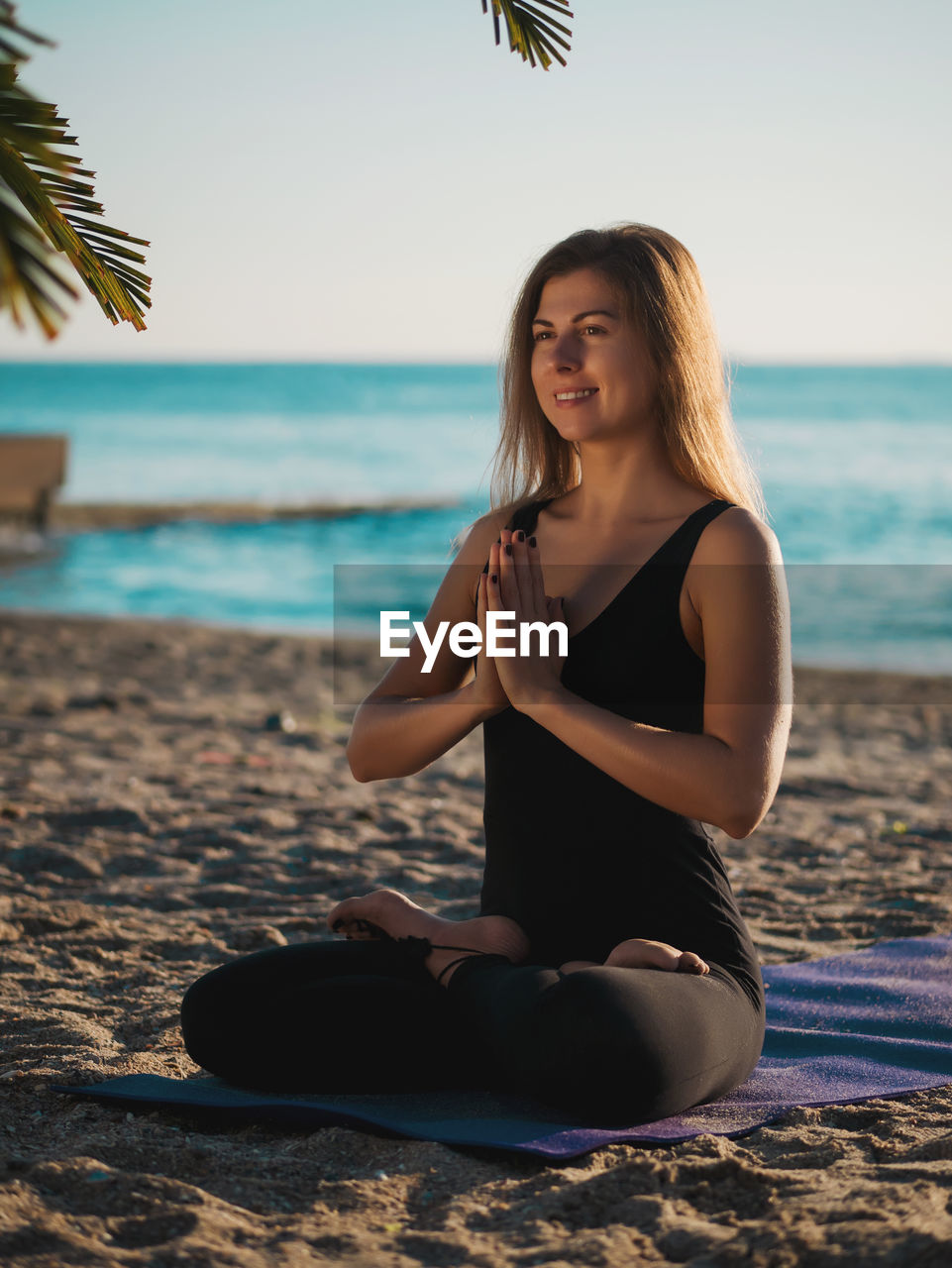 Woman doing yoga at beach