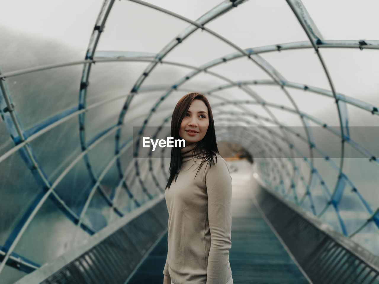 Woman standing under covered bridge