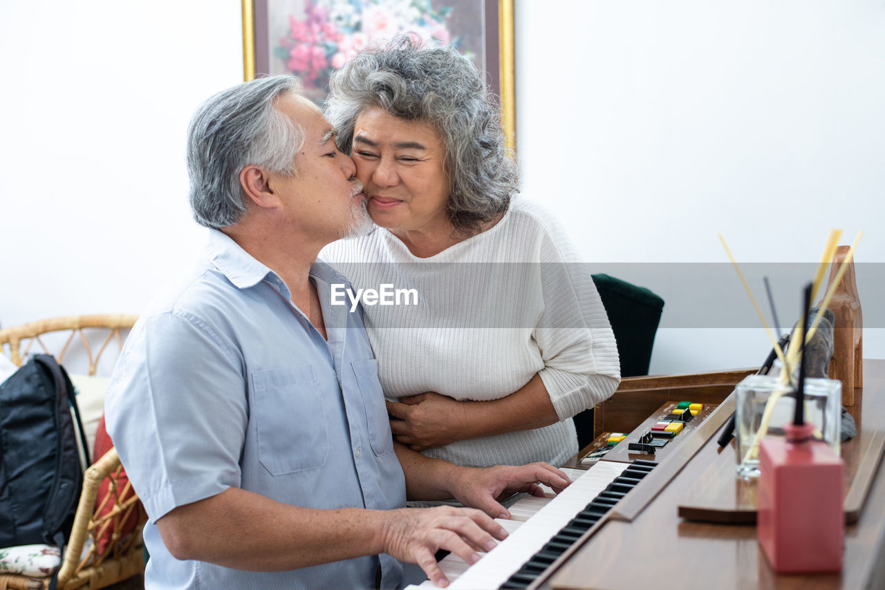 Retreatment elderly asian grandmother and grandfather play piano in home with love moment.