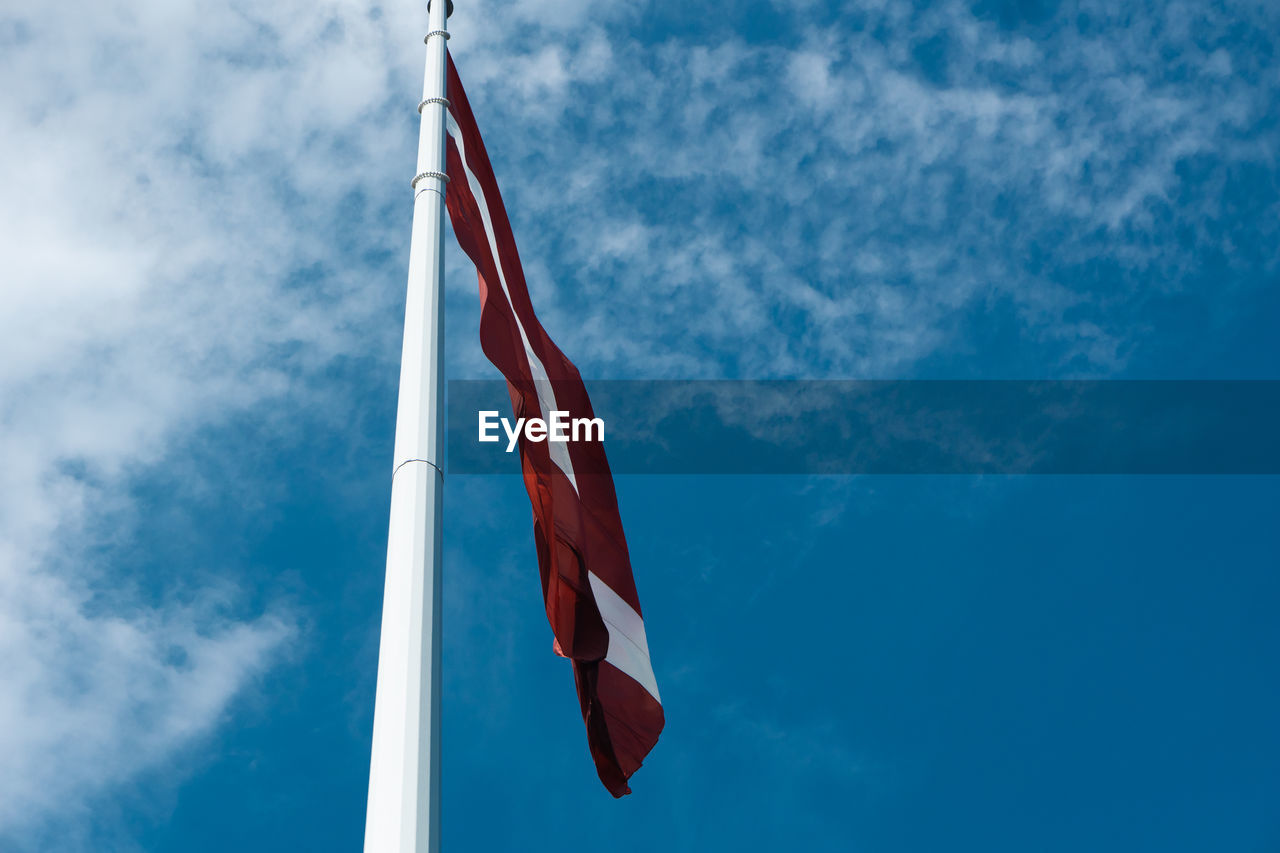 Low angle view of latvian flag against sky