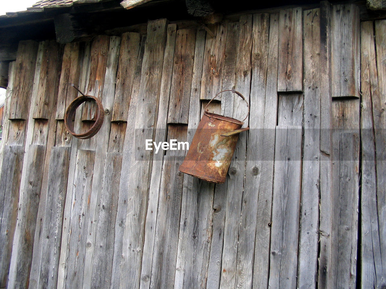 Close-up of old rusty hanging on wood