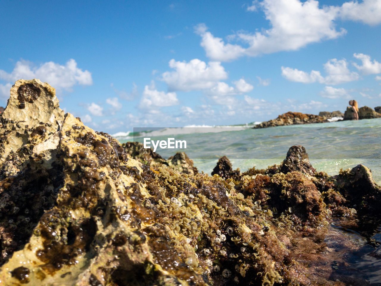 SCENIC VIEW OF ROCKS ON BEACH AGAINST SKY