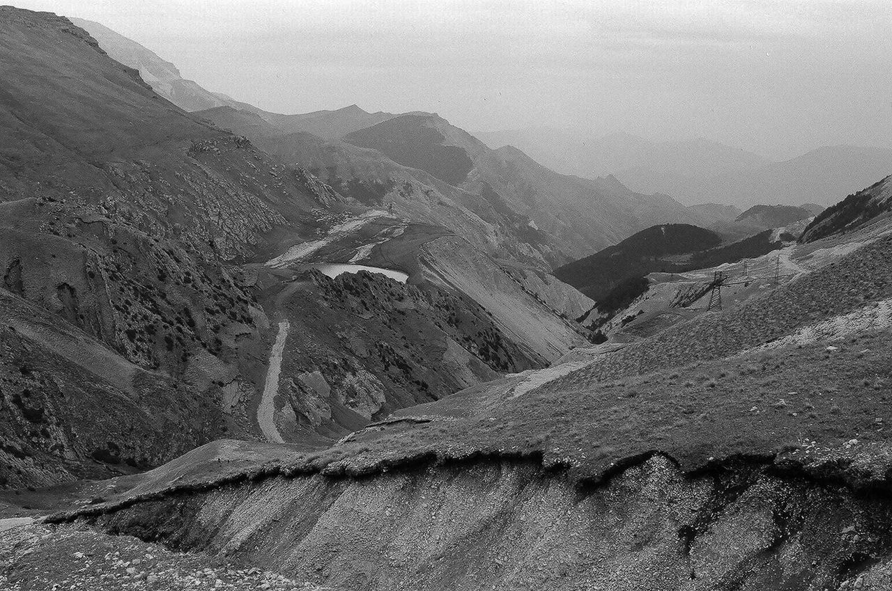 SCENIC VIEW OF MOUNTAIN ROAD AGAINST SKY