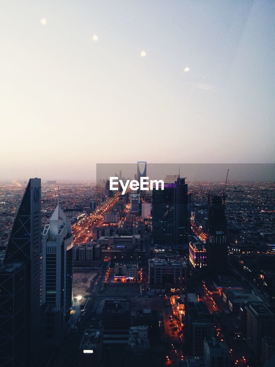 Aerial view of illuminate cityscape against sky at dusk