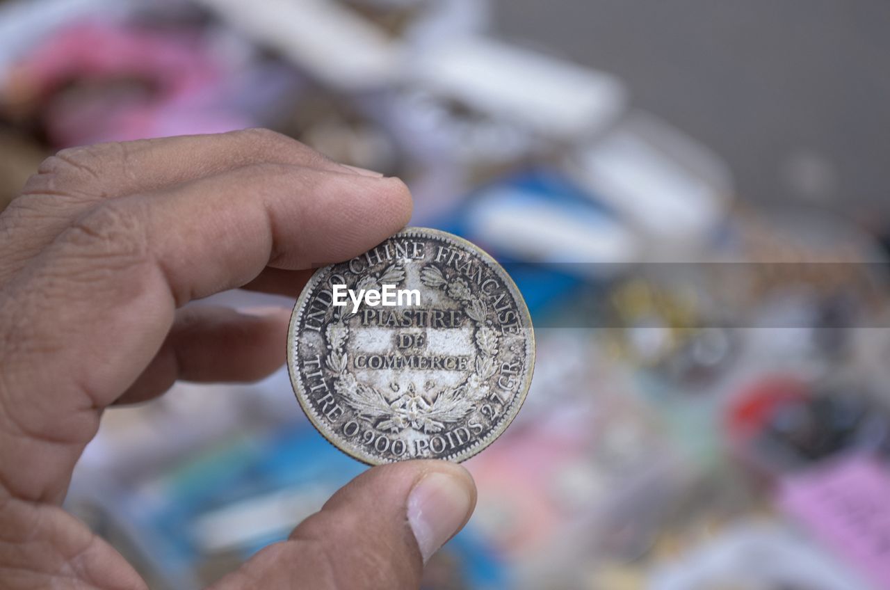 Cropped hand of person holding coin