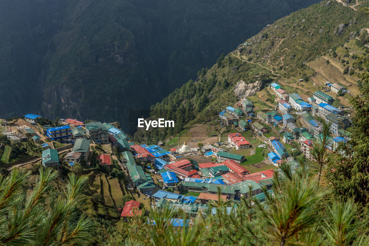 High angle view of townscape by trees on mountain