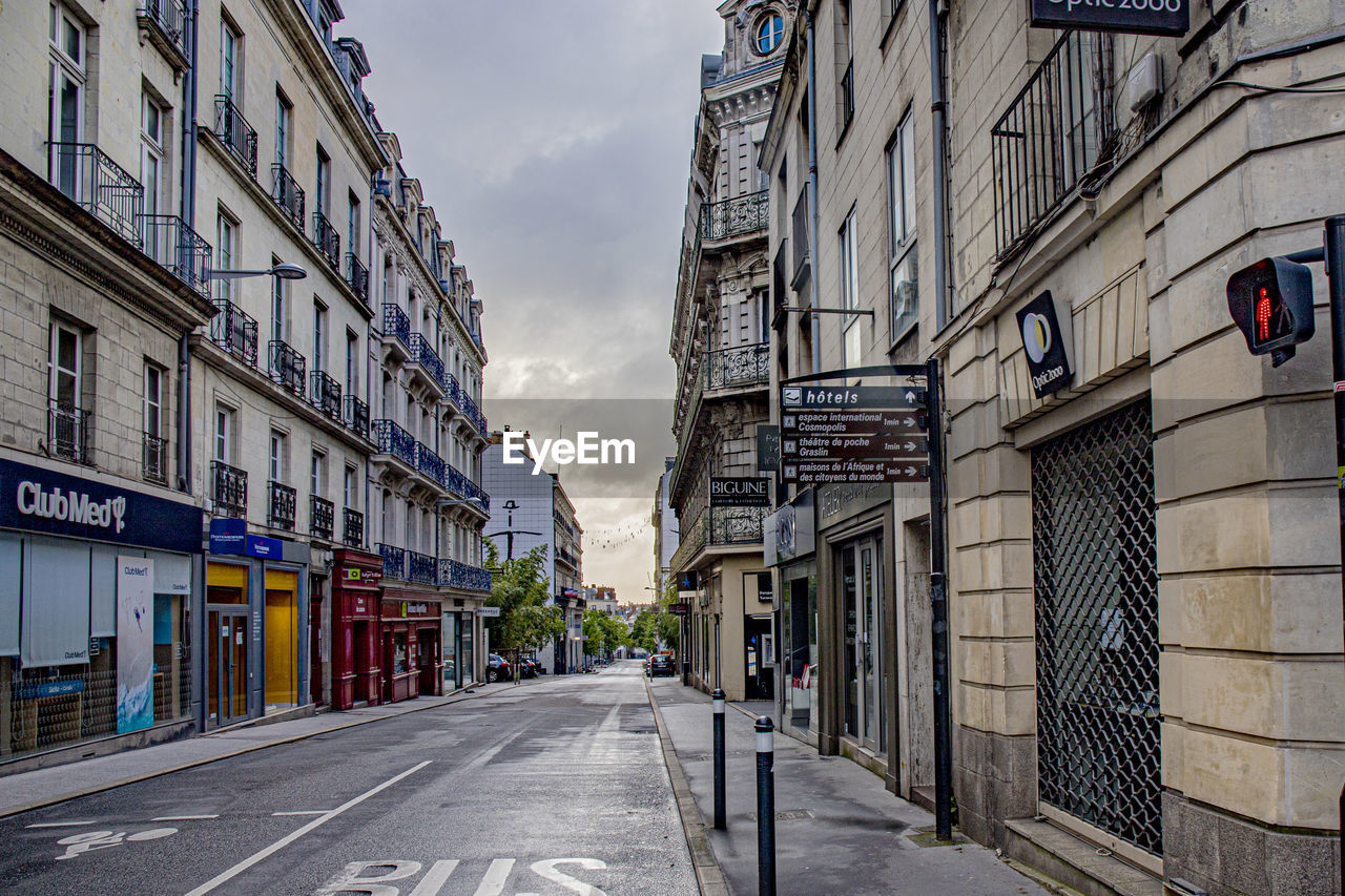 Empty road amidst buildings in city