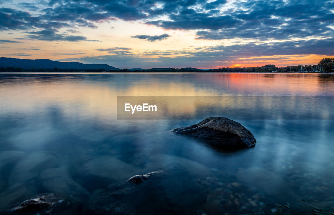 SCENIC VIEW OF ROCK IN LAKE AGAINST SKY