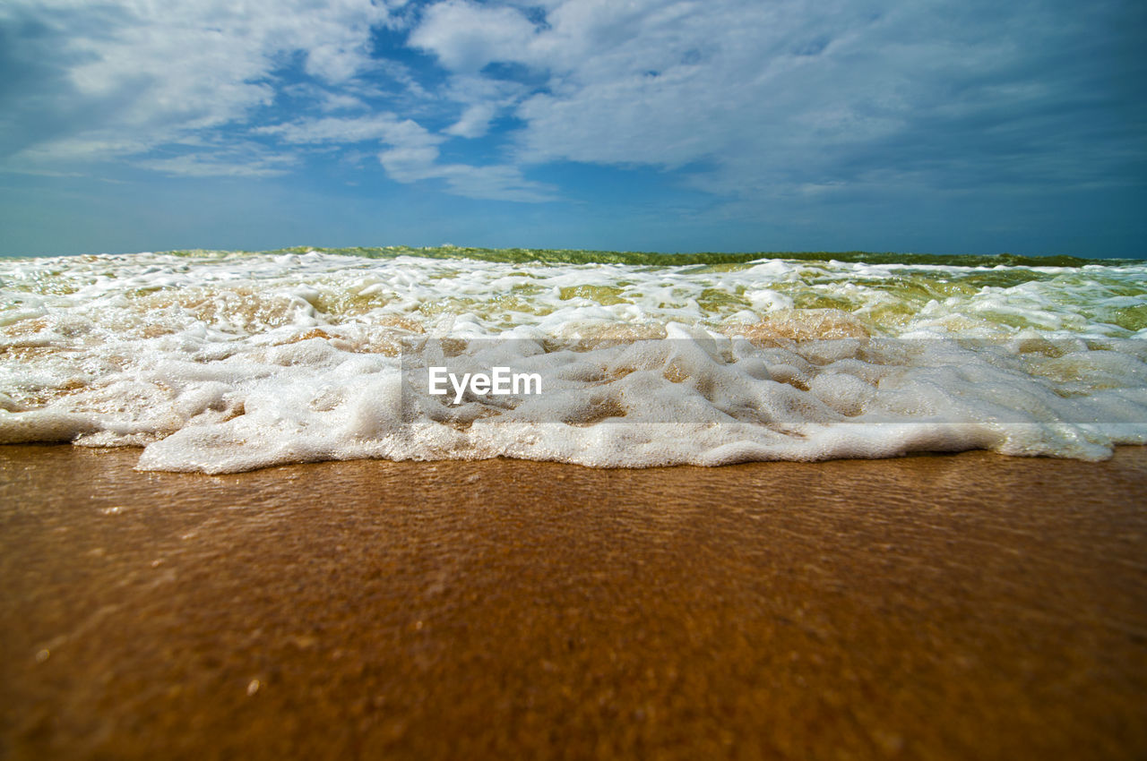 Surface level of waves in sea against sky