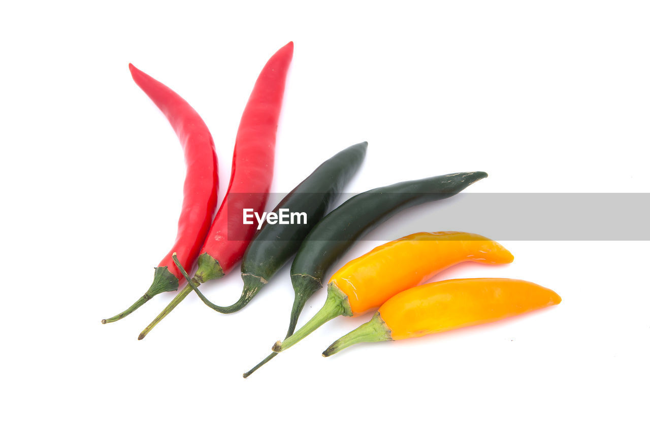 CLOSE-UP OF RED CHILI PEPPERS AGAINST WHITE BACKGROUND