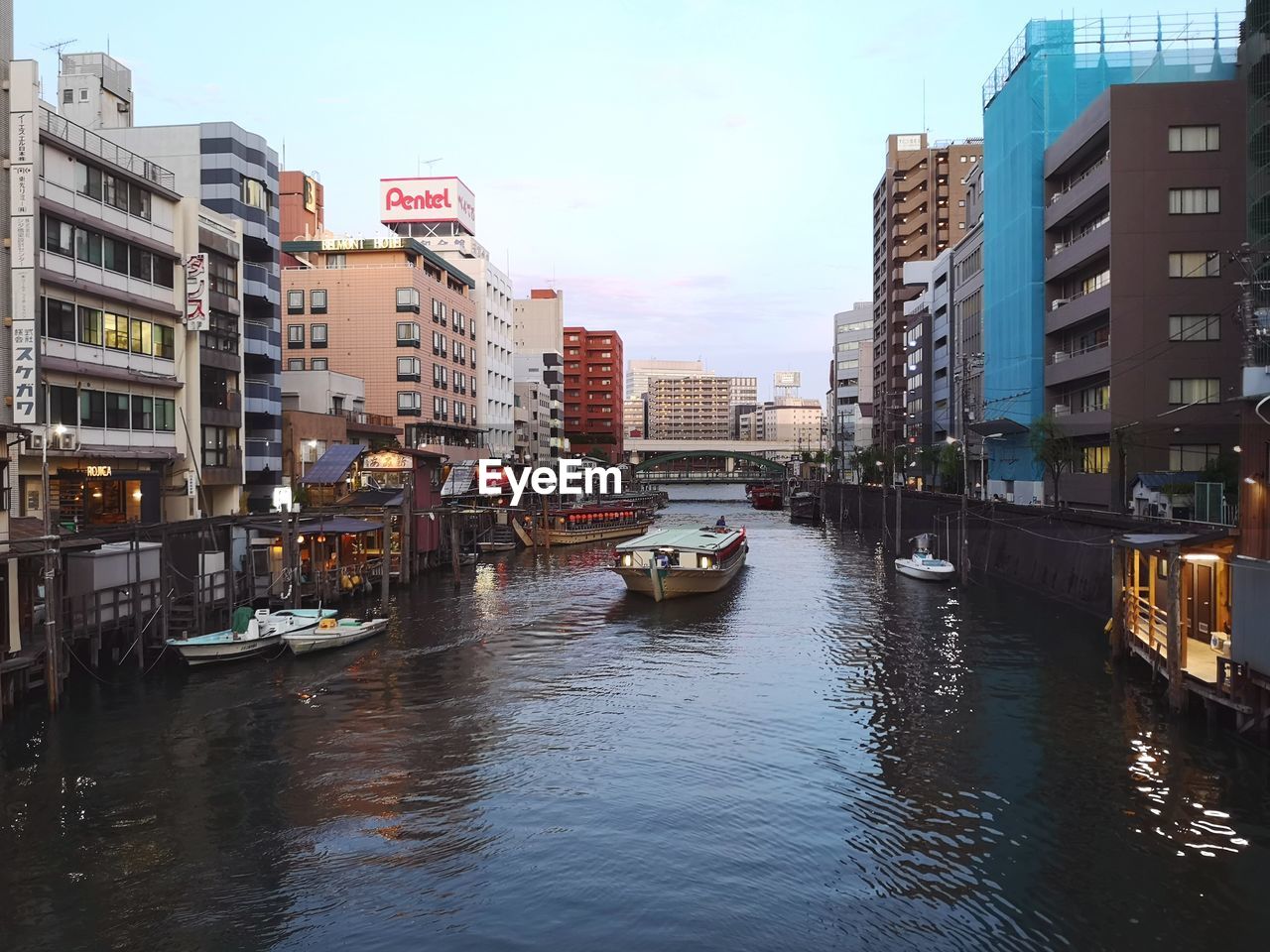 Canal amidst buildings in city against sky