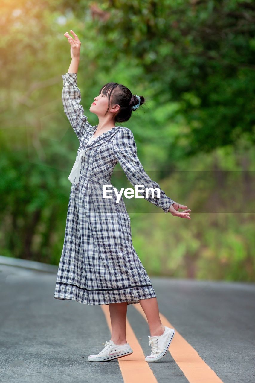 Side view of woman standing on road