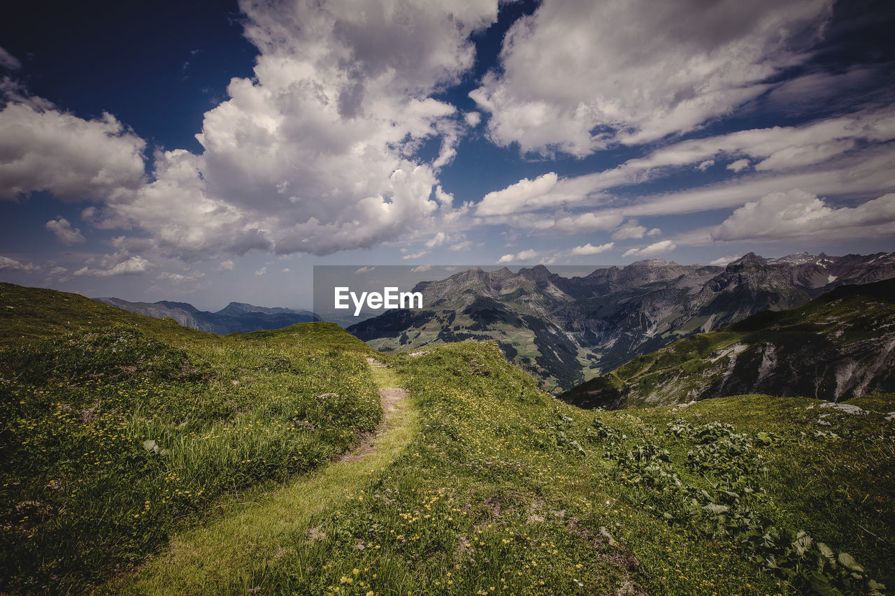 Scenic view of mountains against cloudy sky