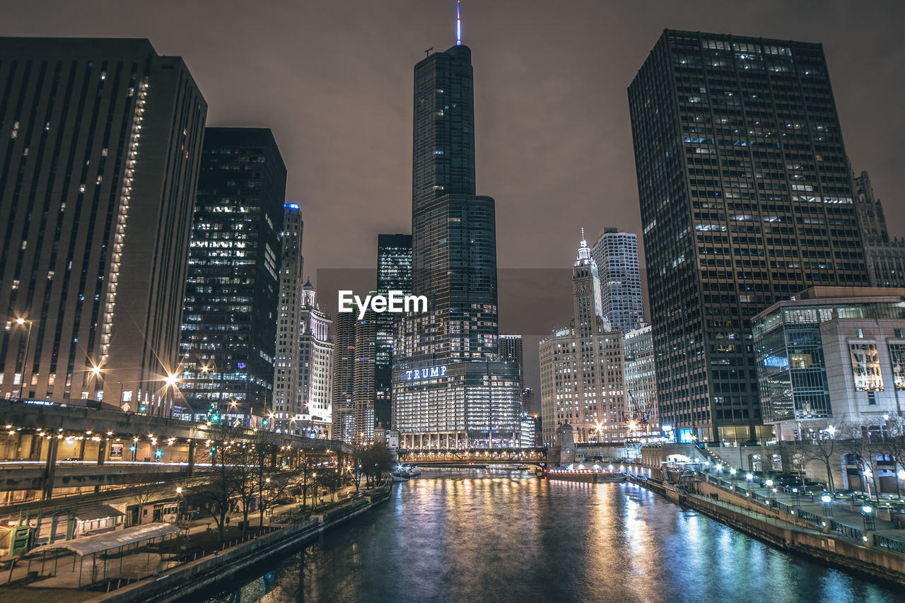 SKYSCRAPERS LIT UP AT NIGHT IN CITY