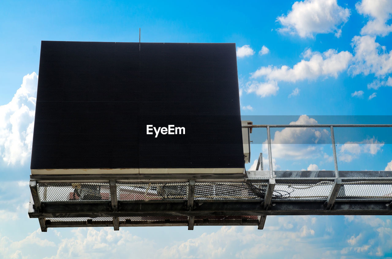 Low angle view of blank billboard against blue sky