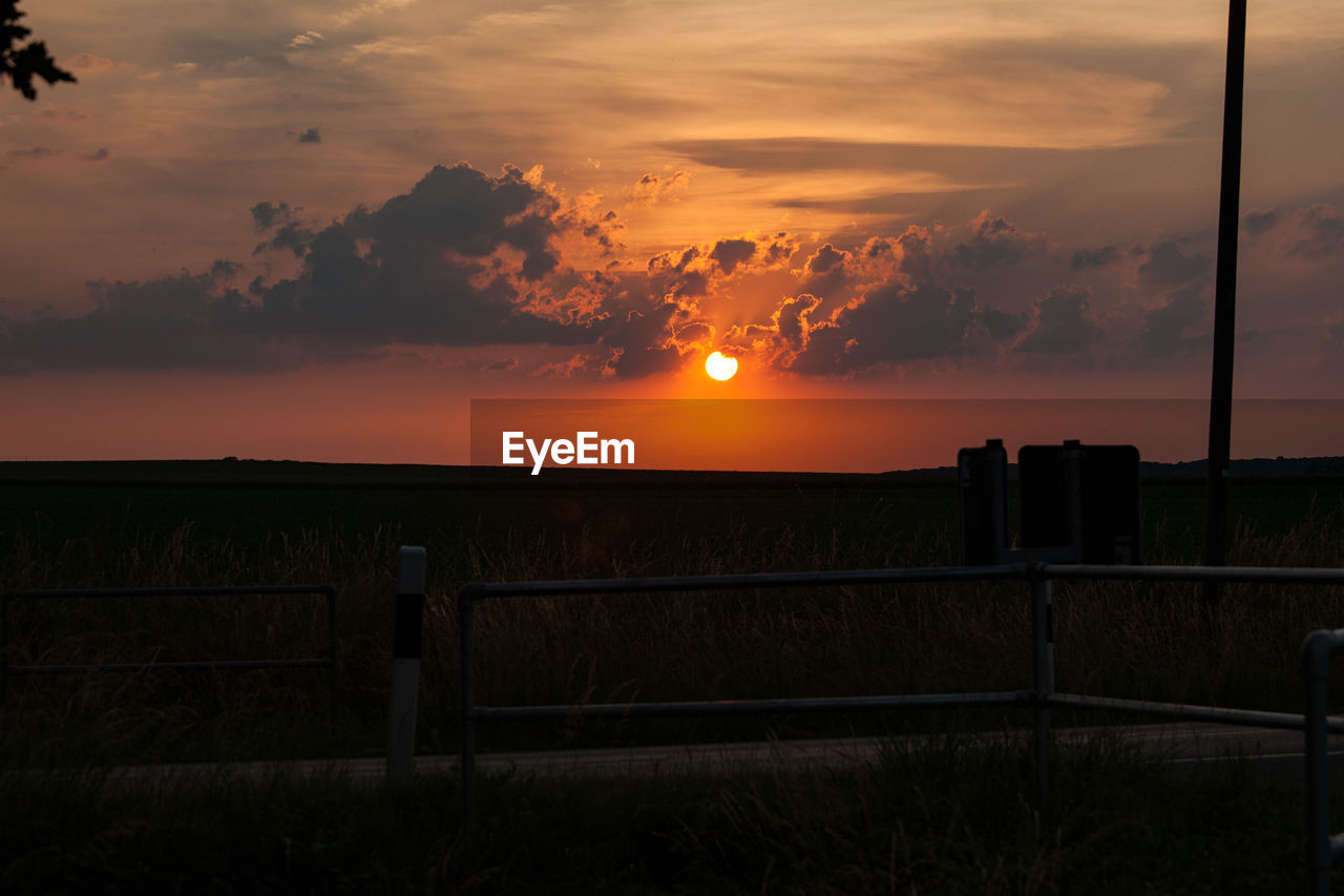 SCENIC VIEW OF SUNSET OVER FIELD