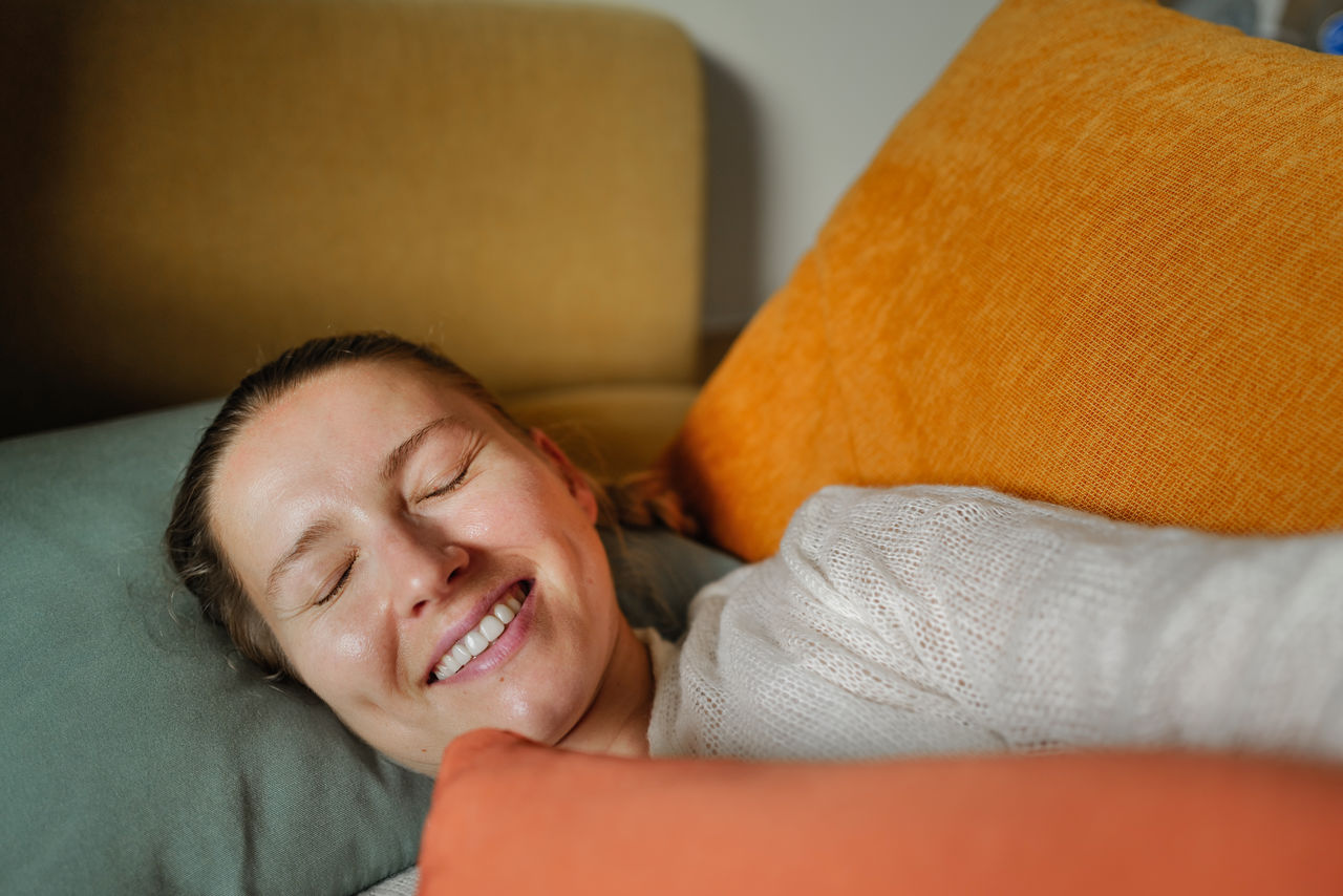 Woman relaxing on the colorful pillows smiling