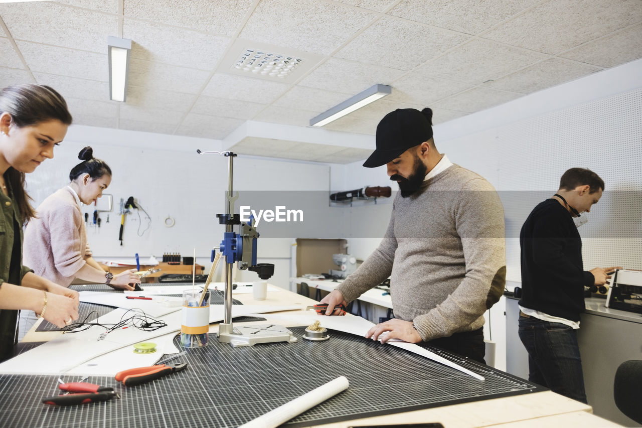 Engineers working on desk at workshop in creative office