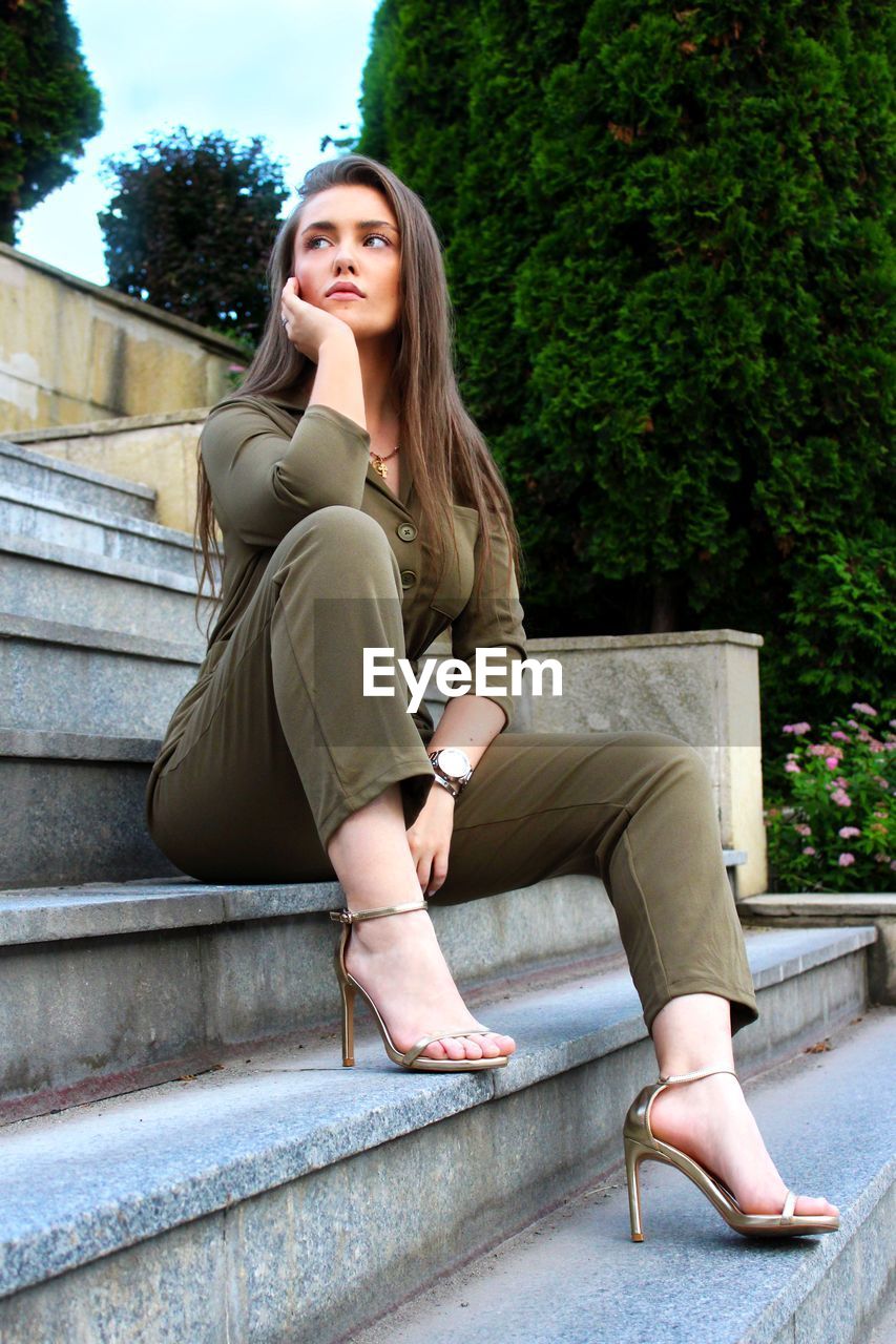 PORTRAIT OF WOMAN SITTING ON SEAT