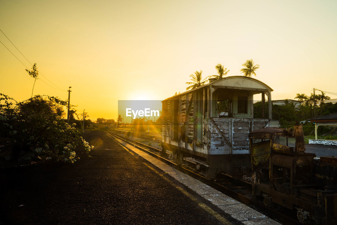 RAILROAD TRACKS AMIDST TREES AGAINST SKY