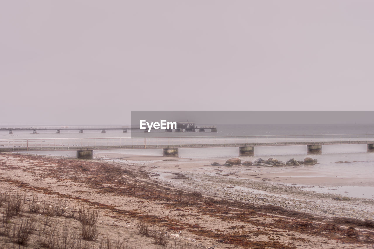 Scenic view of sea against clear sky during foggy weather