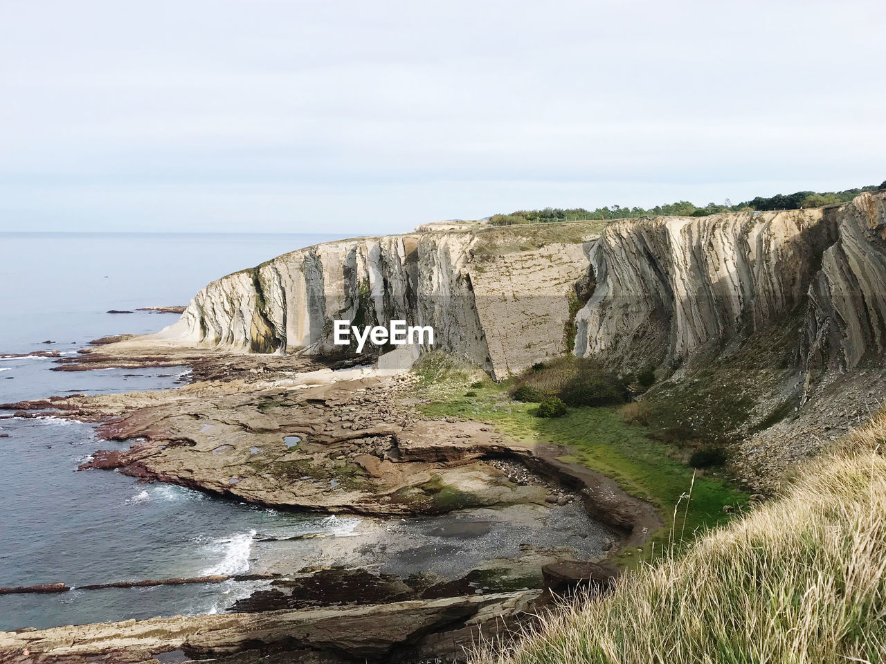 Rock formations by sea against sky