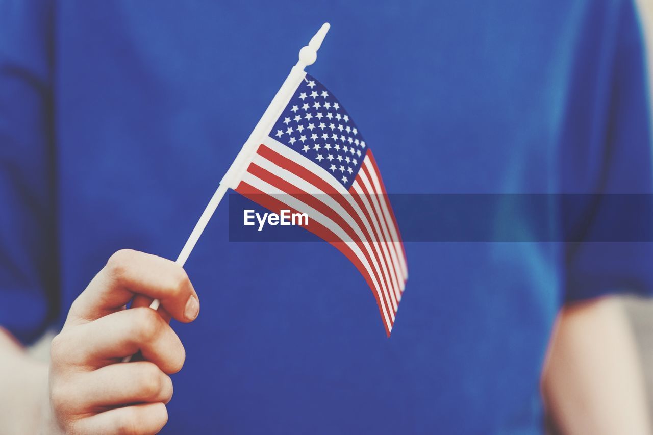 Midsection of person holding american flag