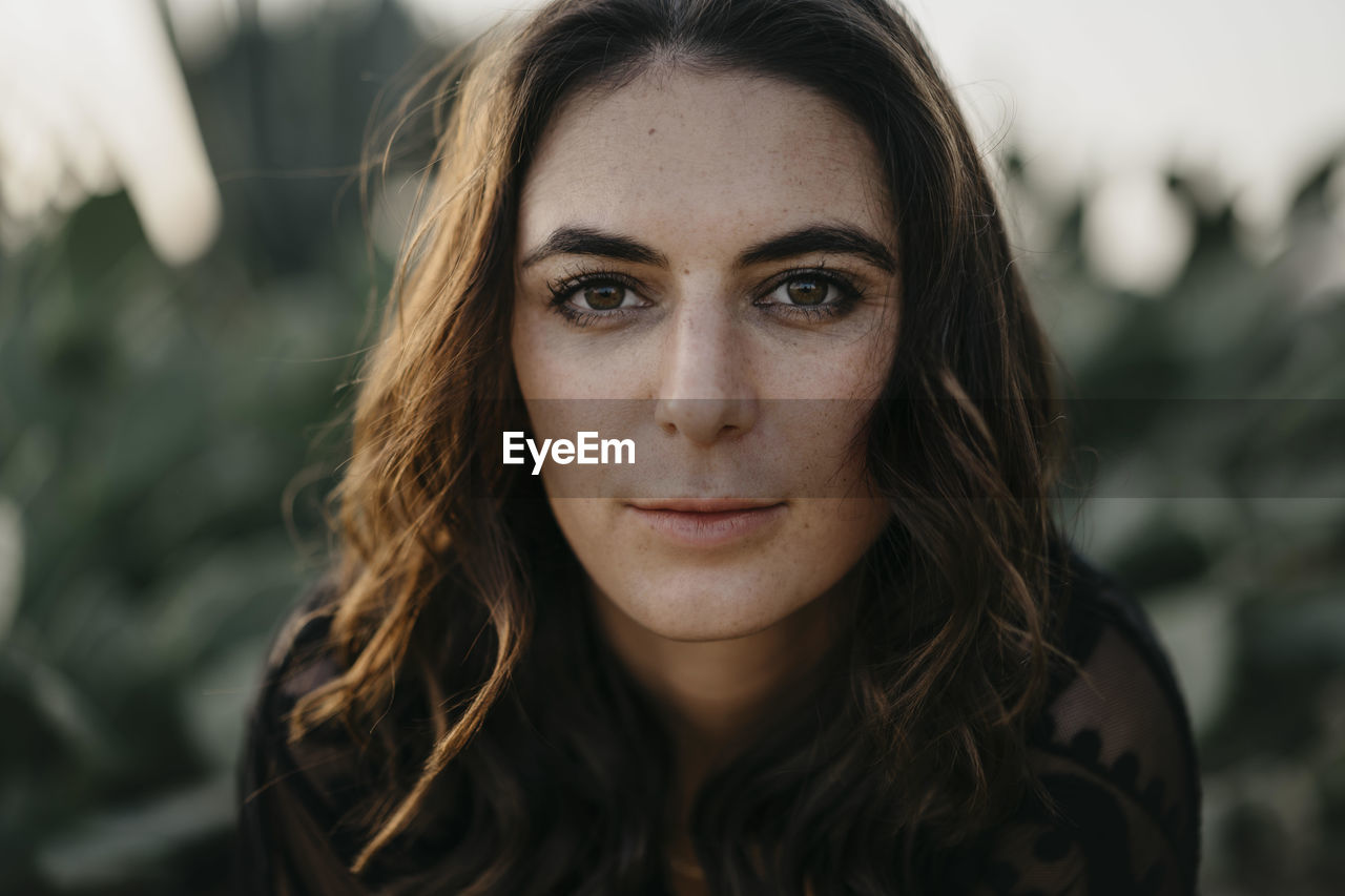 Confident young woman with brown eyes during sunset