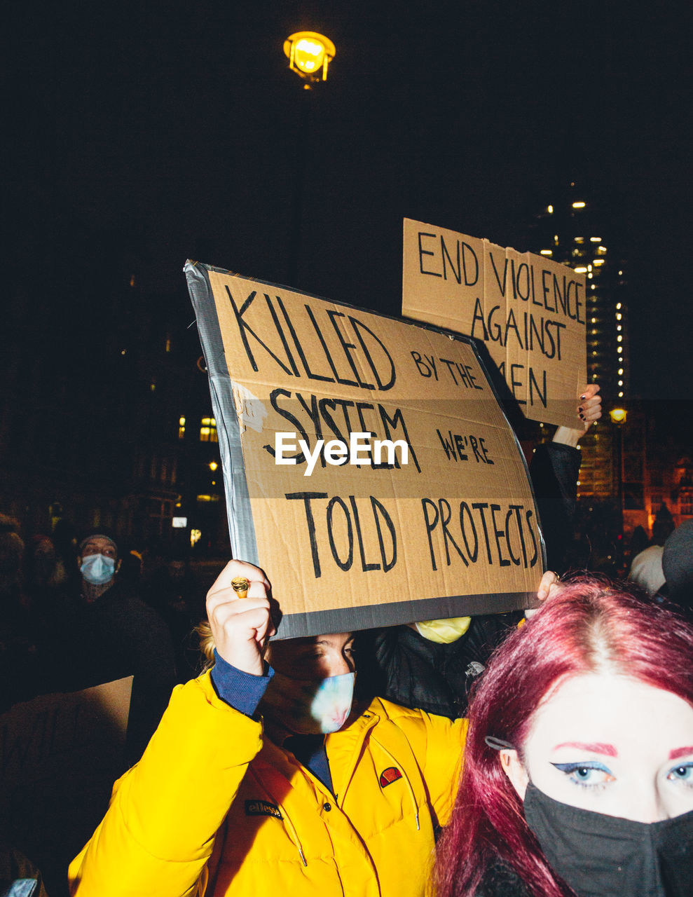 PORTRAIT OF WOMAN WITH TEXT ON STREET IN CITY