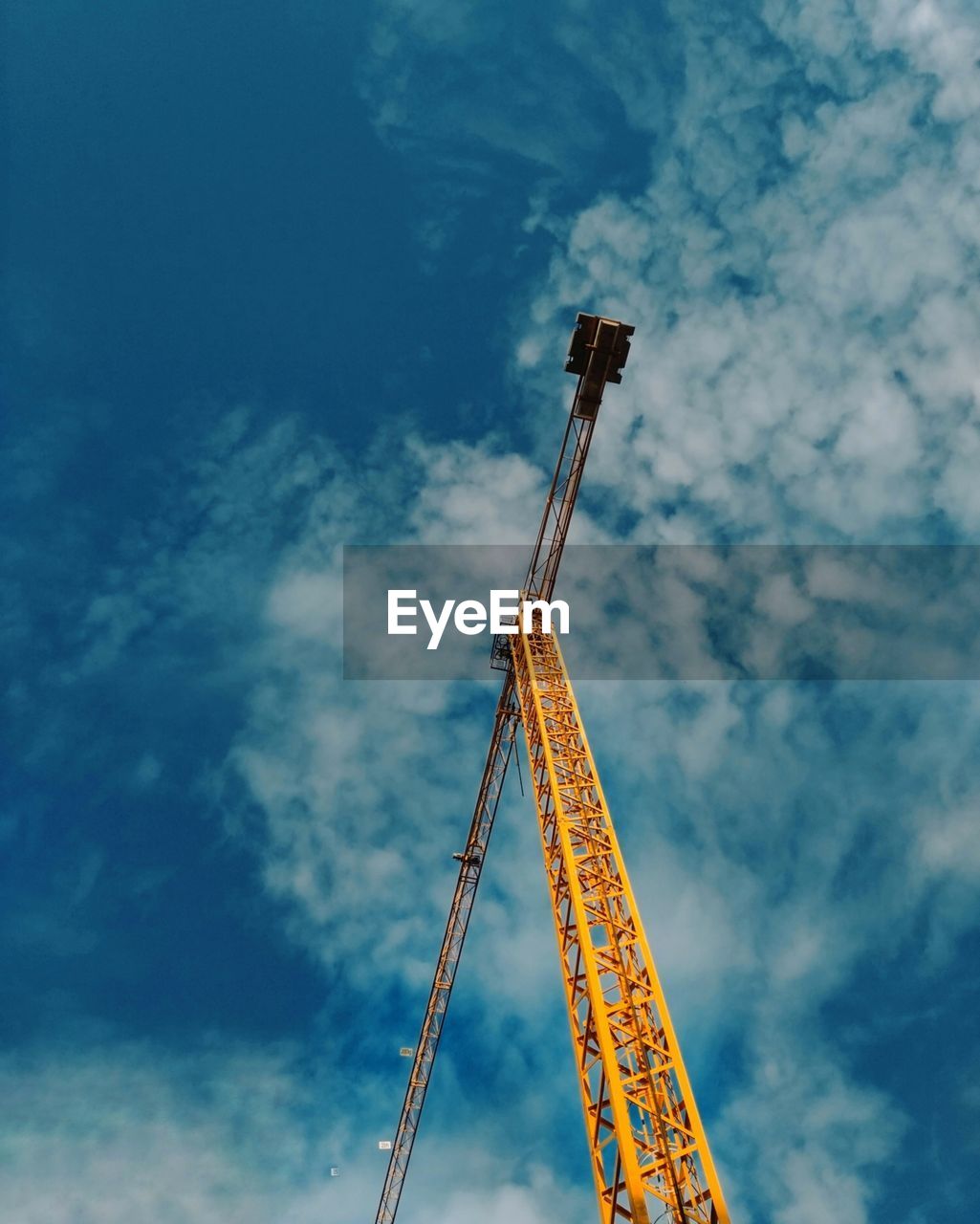 LOW ANGLE VIEW OF CRANES AGAINST BLUE SKY