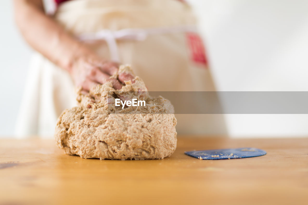 Close-up of hand kneading dough