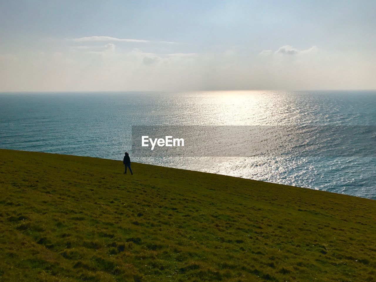 Mid distance view of silhouette person standing at beach