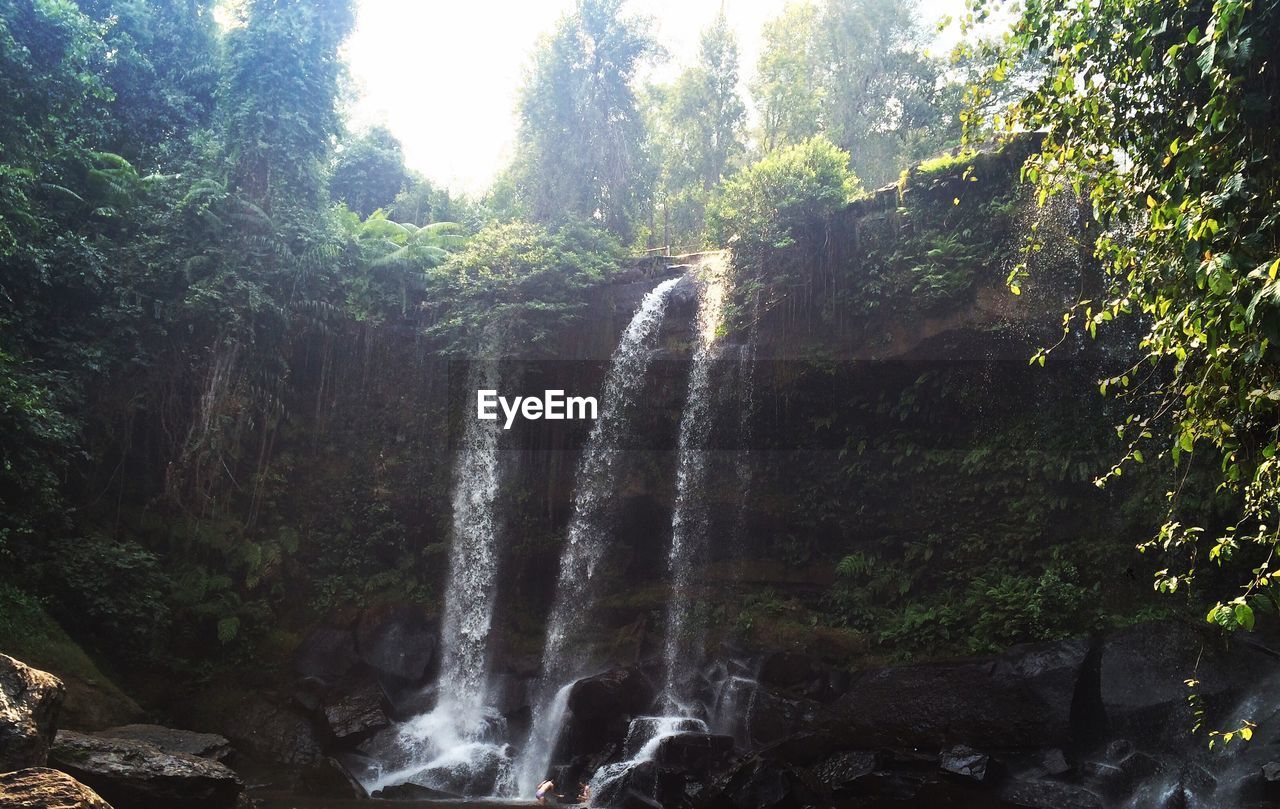 LOW ANGLE VIEW OF WATERFALL AGAINST SKY