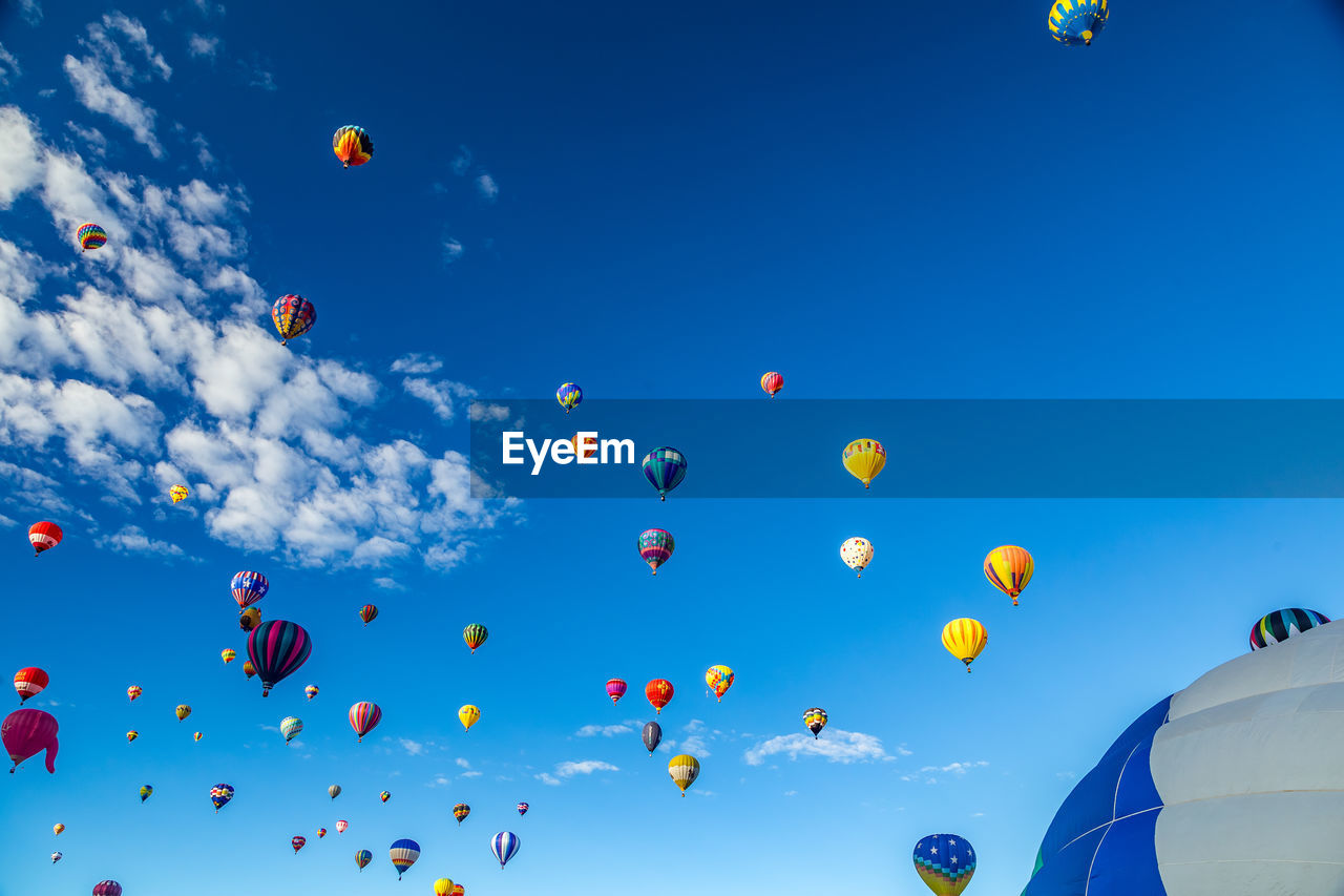 Low angle view of hot air balloons flying against sky