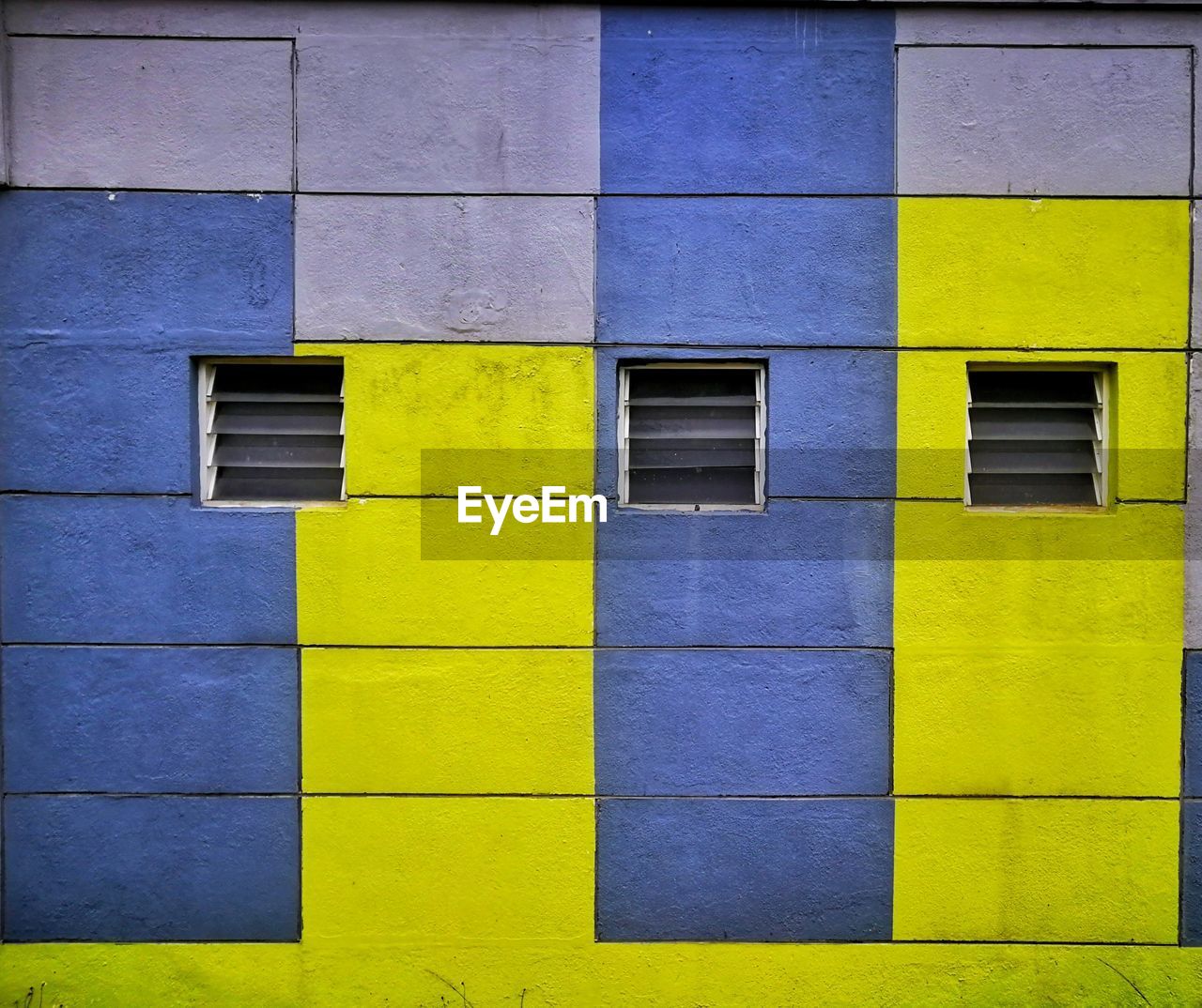 FULL FRAME SHOT OF MULTI COLORED WALL WITH BUILDING