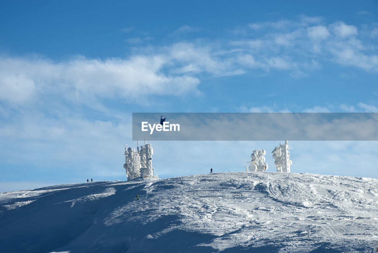 Telecommunication towers on snowly mountain  against sky