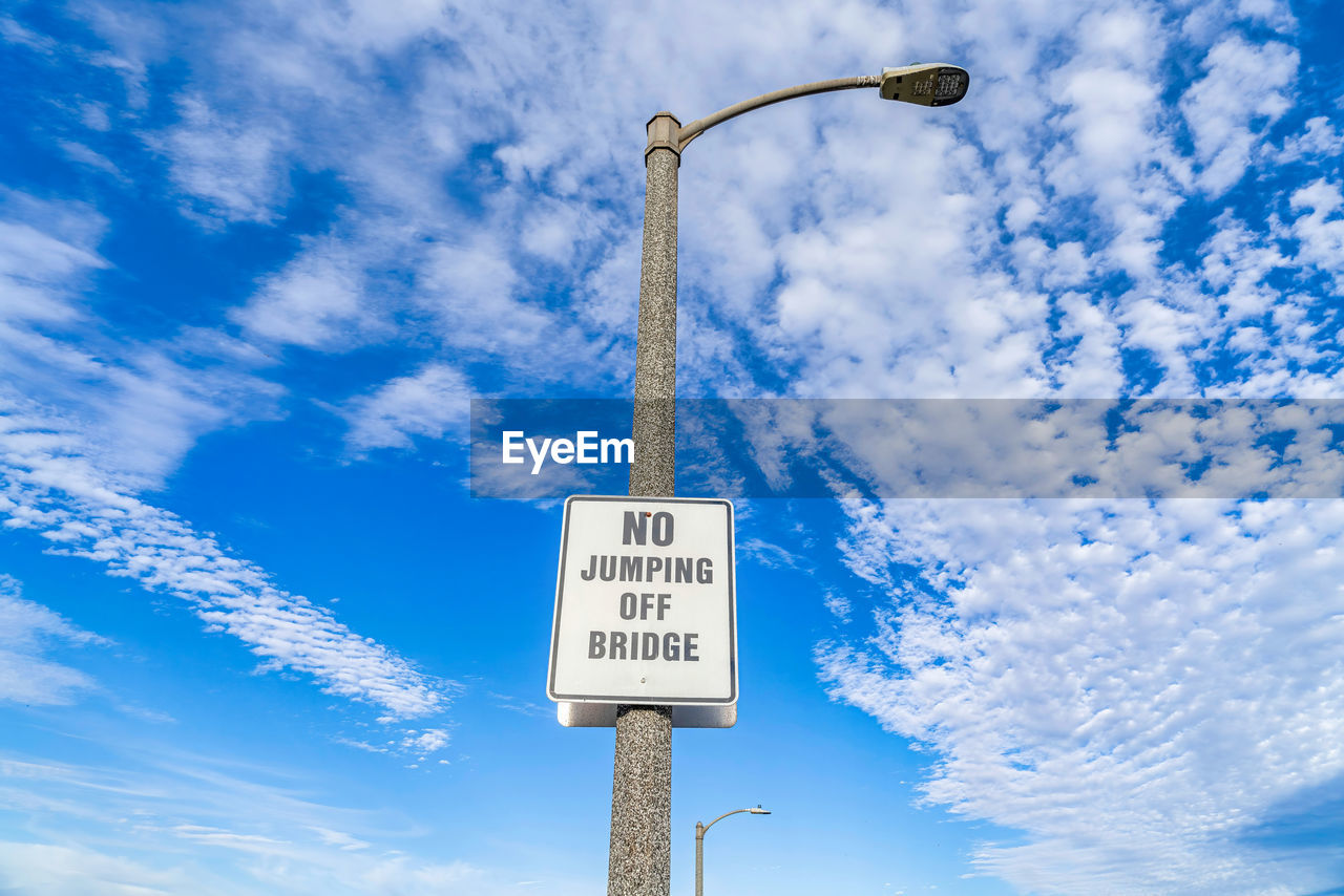 LOW ANGLE VIEW OF ROAD SIGNS AGAINST SKY